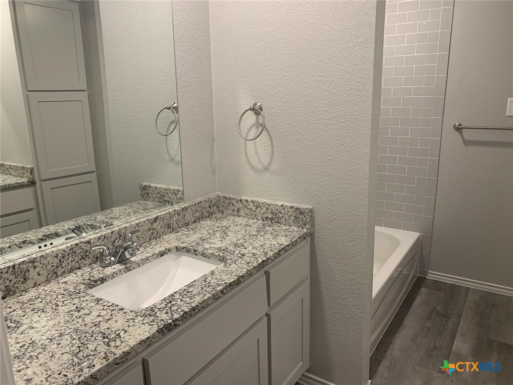 716 Kimble Drive, Unit B Temple, TX 76501 - Photo 8 of 23 a bathroom with a granite countertop sink and a mirror