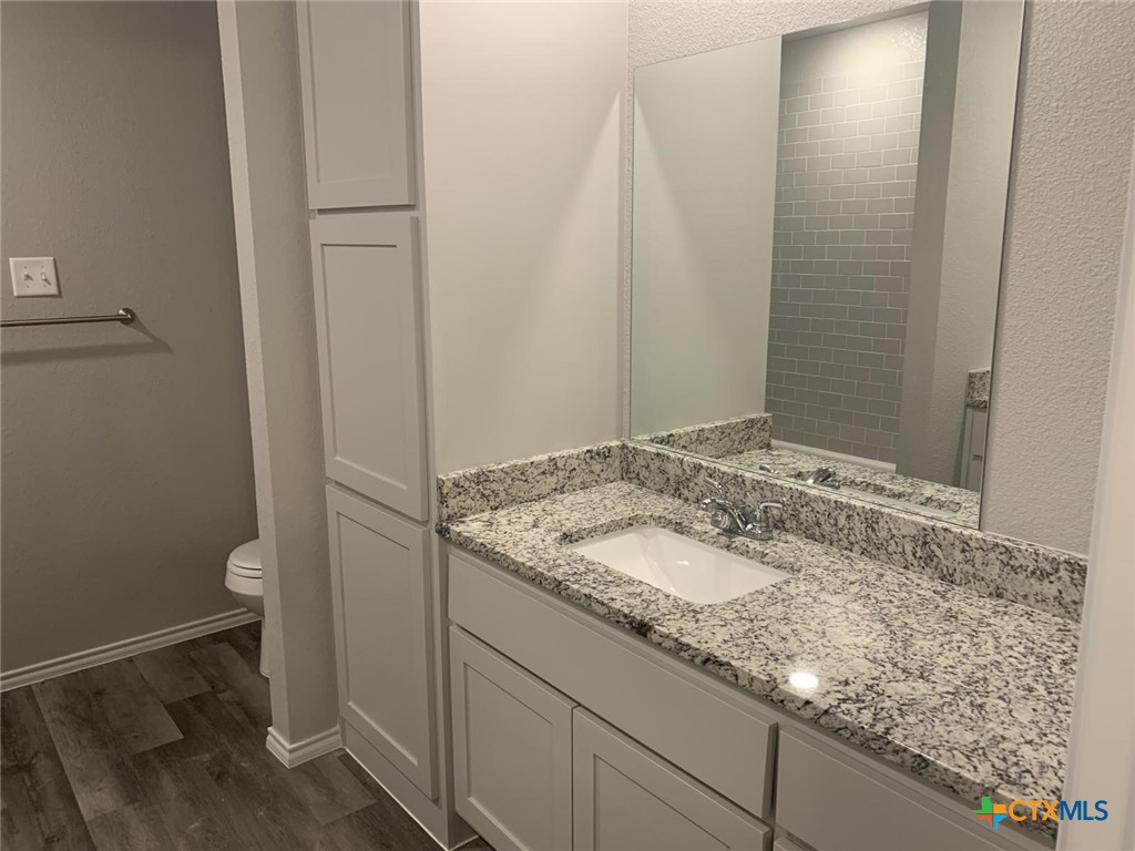 716 Kimble Drive, Unit B Temple, TX 76501 - Photo 9 of 23 a bathroom with a granite countertop sink and a mirror