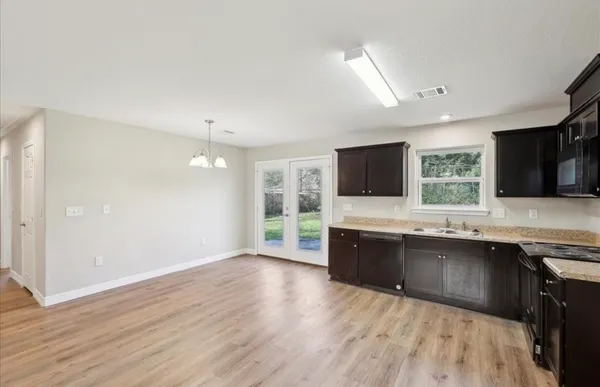 a large kitchen with stainless steel appliances granite countertop a sink and cabinets