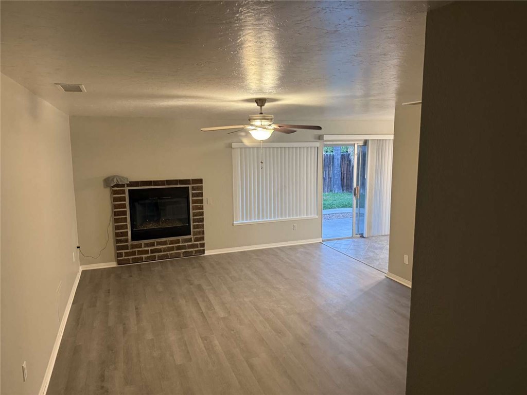 3270 Edgemont Court San Bernardino, CA 92405 - Photo 8 of 44 an empty room with wooden floor fireplace and chandelier