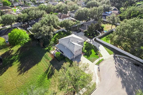 an aerial view of a house with a yard and lake