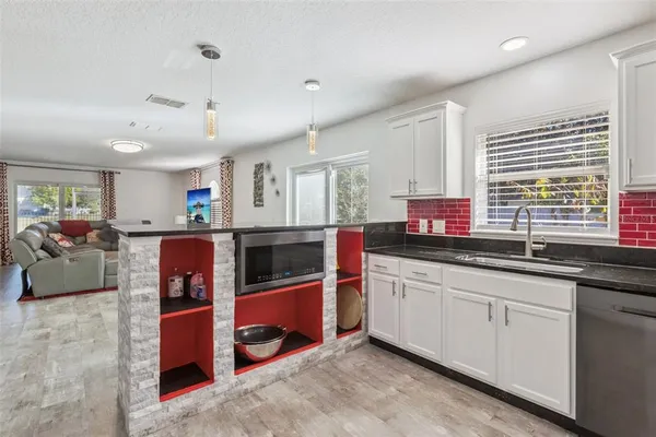 a large kitchen with stainless steel appliances kitchen island granite countertop a sink and cabinets