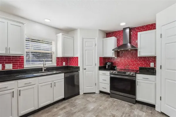 a kitchen with stainless steel appliances granite countertop a stove and a sink