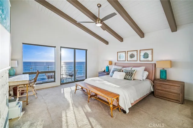 a bedroom with a bed a desk and chair with the large mirror