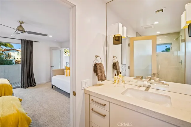 a en suite bathroom with a double vanity sink a mirror and a bathtub