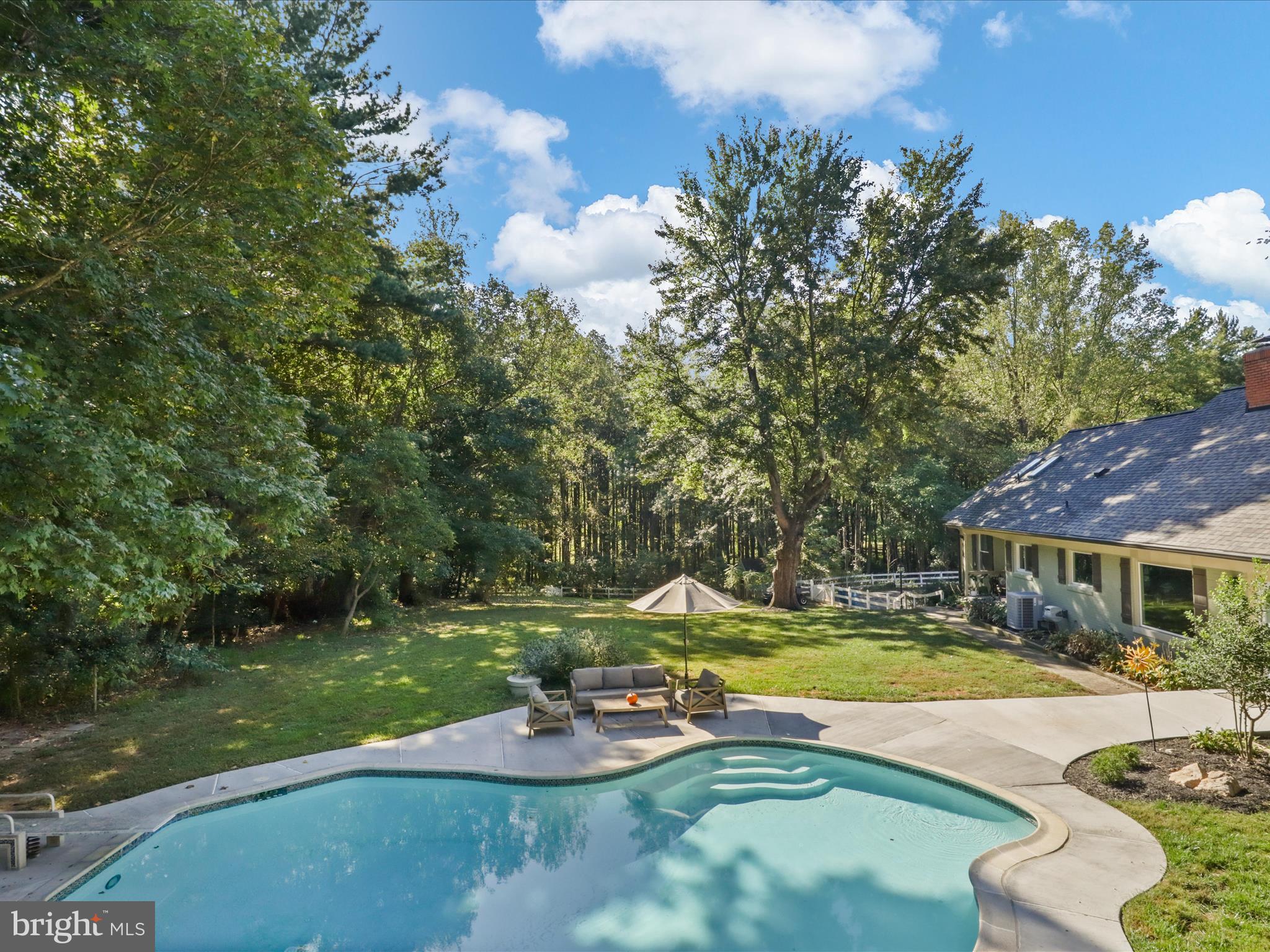 6811 White Rock Road Clifton, VA 20124 - Photo 72 of 87 a view of a swimming pool with lounge chairs in back yard of the house
