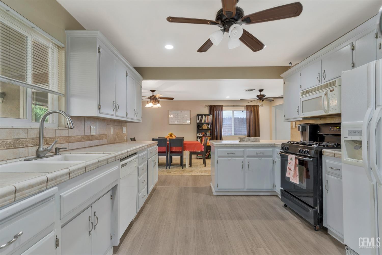 Undisclosed Address Bakersfield, CA 93306 - Photo 16 of 40 a kitchen with kitchen island granite countertop a sink counter top space appliances and cabinets