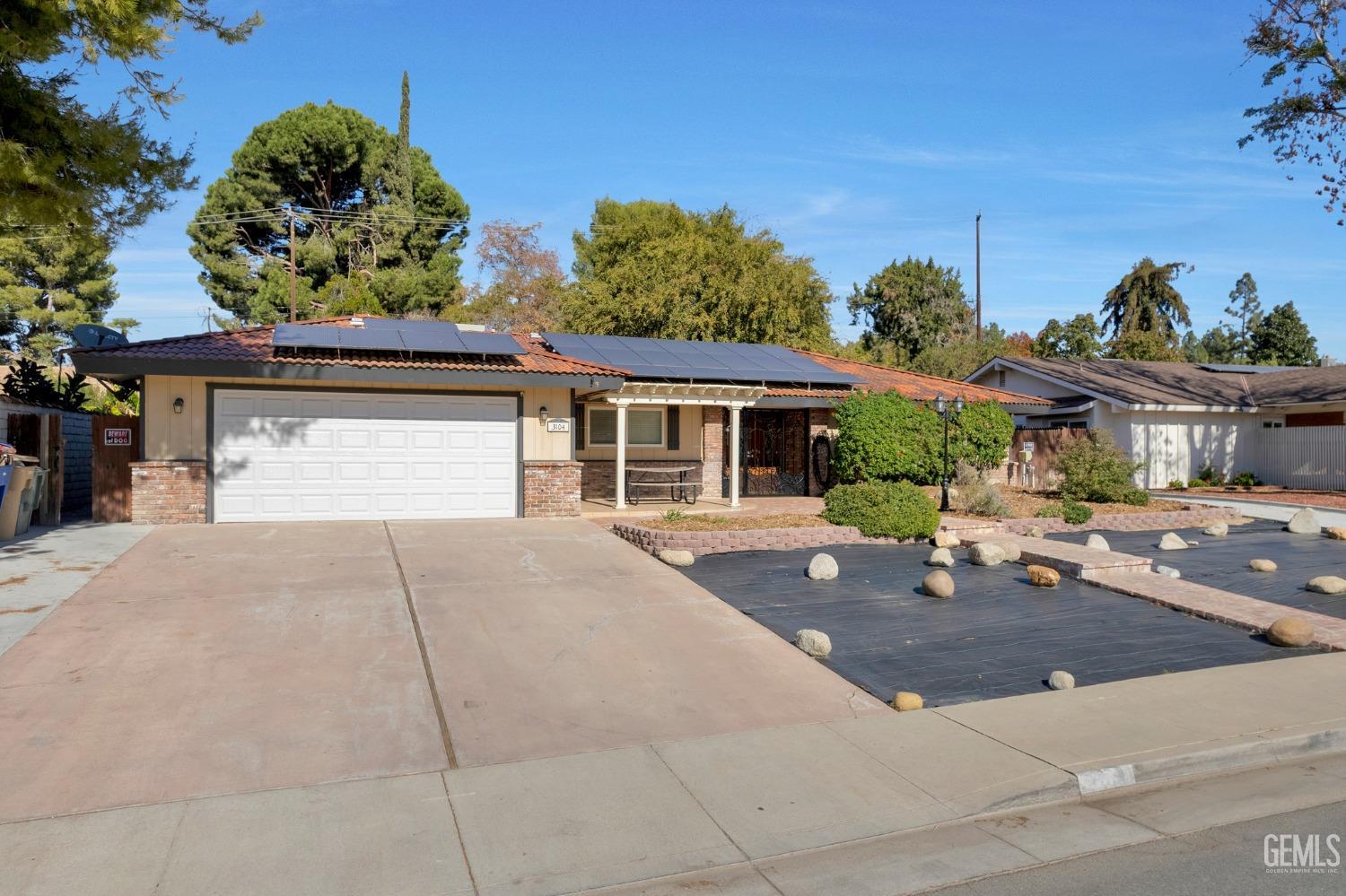 Undisclosed Address Bakersfield, CA 93306 - Photo 3 of 40 a front view of a house with a yard and garage