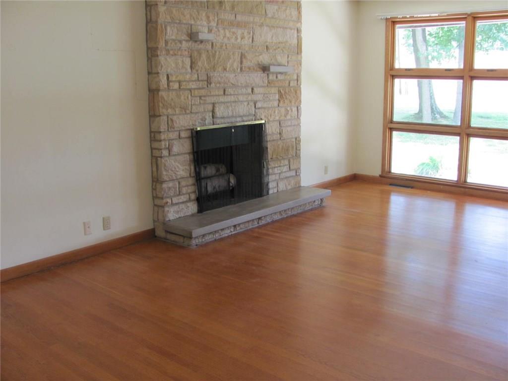 4989 Seneca Road Sharpsville, PA 16150 - Photo 9 of 19 Living room fireplace with wall of windows to front yard. The floors are beautiful