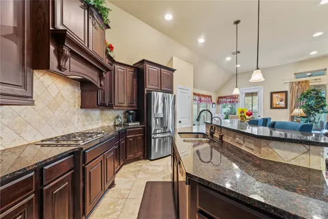 a kitchen with granite countertop stainless steel appliances and wooden cabinets