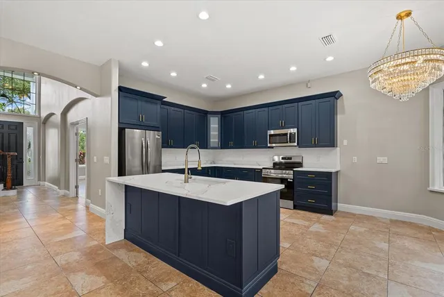 a kitchen with stainless steel appliances granite countertop a sink stove and refrigerator