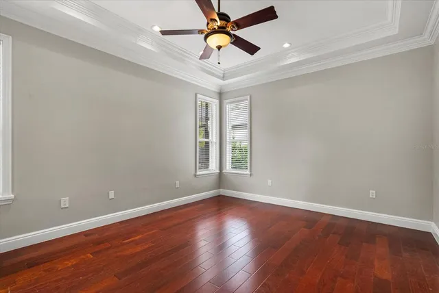 a view of an empty room with a window and wooden floor