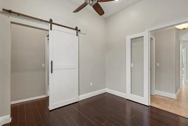 a view of a livingroom with a ceiling fan & kitchen space