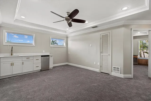 an empty room with windows closet and chandelier fan