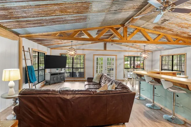 a living room with furniture a flat screen tv and a table