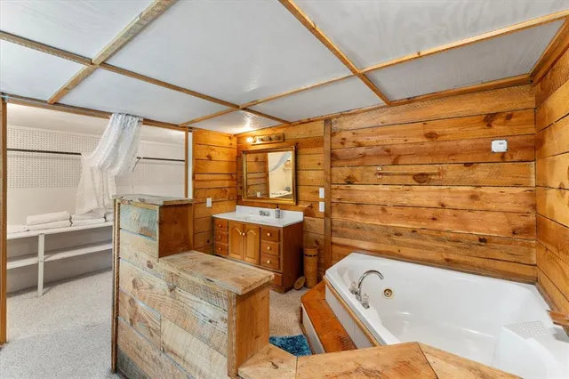 a bathroom with a tub sink and mirror