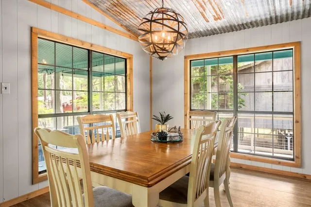 a dining room with furniture a chandelier and wooden floor