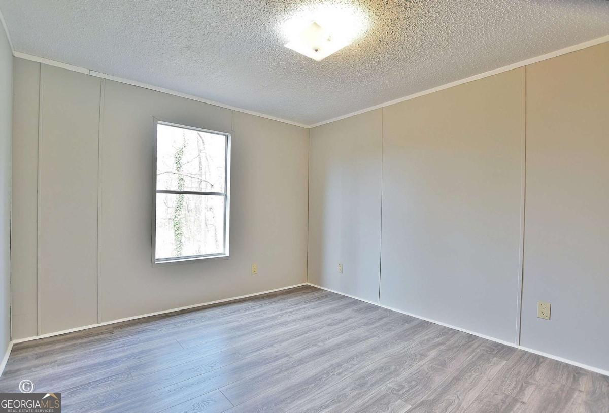 760 Hamilton Mulberry Grove Road Cataula, GA 31804 - Photo 12 of 26 an empty room with wooden floor and windows