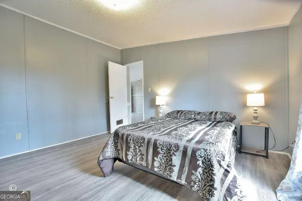 a bedroom with a bed and wooden floor