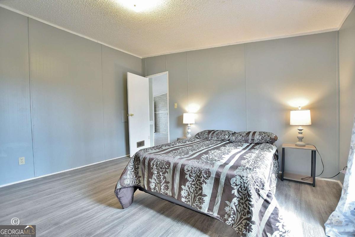 760 Hamilton Mulberry Grove Road Cataula, GA 31804 - Photo 14 of 26 a bedroom with a bed and wooden floor