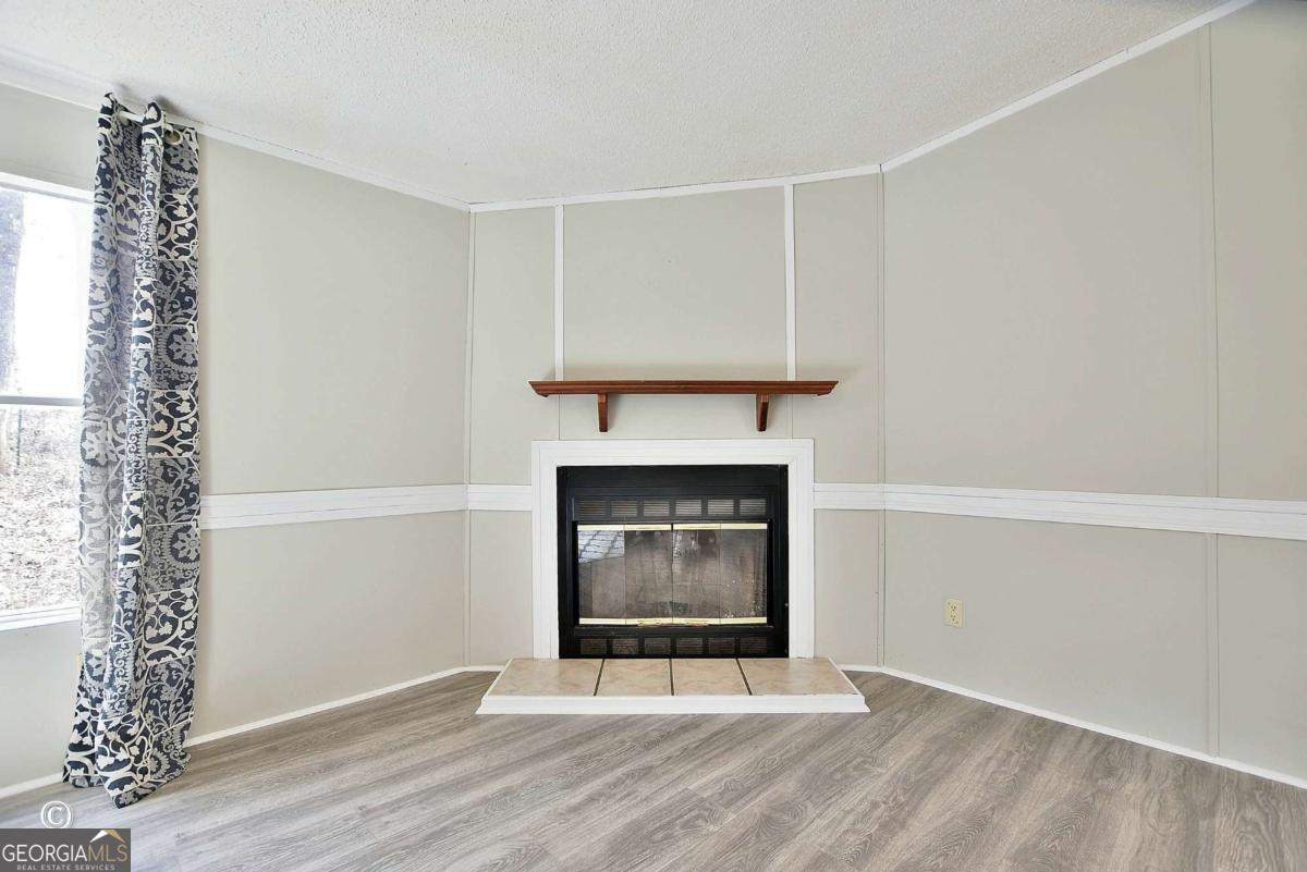 760 Hamilton Mulberry Grove Road Cataula, GA 31804 - Photo 4 of 26 a living room with a fireplace and a window