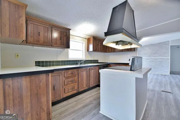 a kitchen with stainless steel appliances granite countertop a sink a stove and a wooden floors