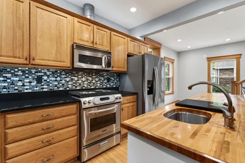 a kitchen with granite countertop a sink stove and refrigerator