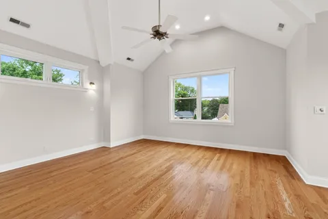 an empty room with windows and ceiling fan