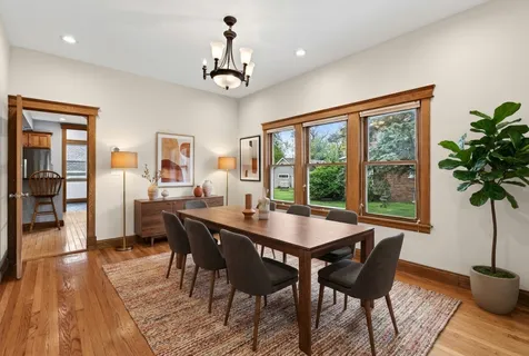 a dining room with furniture window and wooden floor