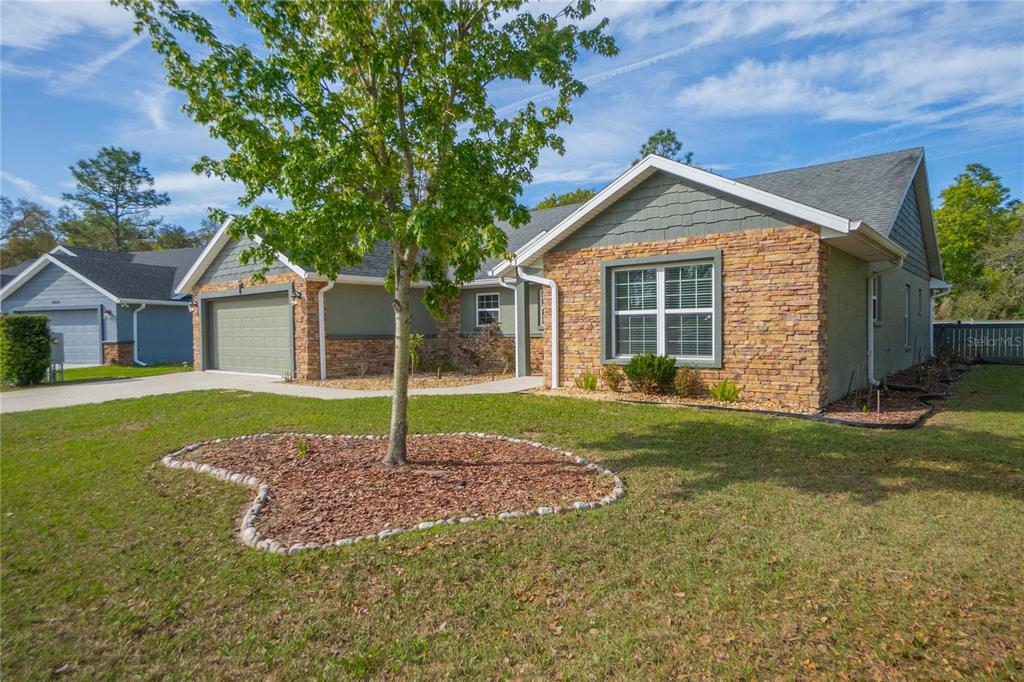 5466 West Tortuga Loop Lecanto, FL 34461 - Photo 2 of 41 a house with green field in front of it