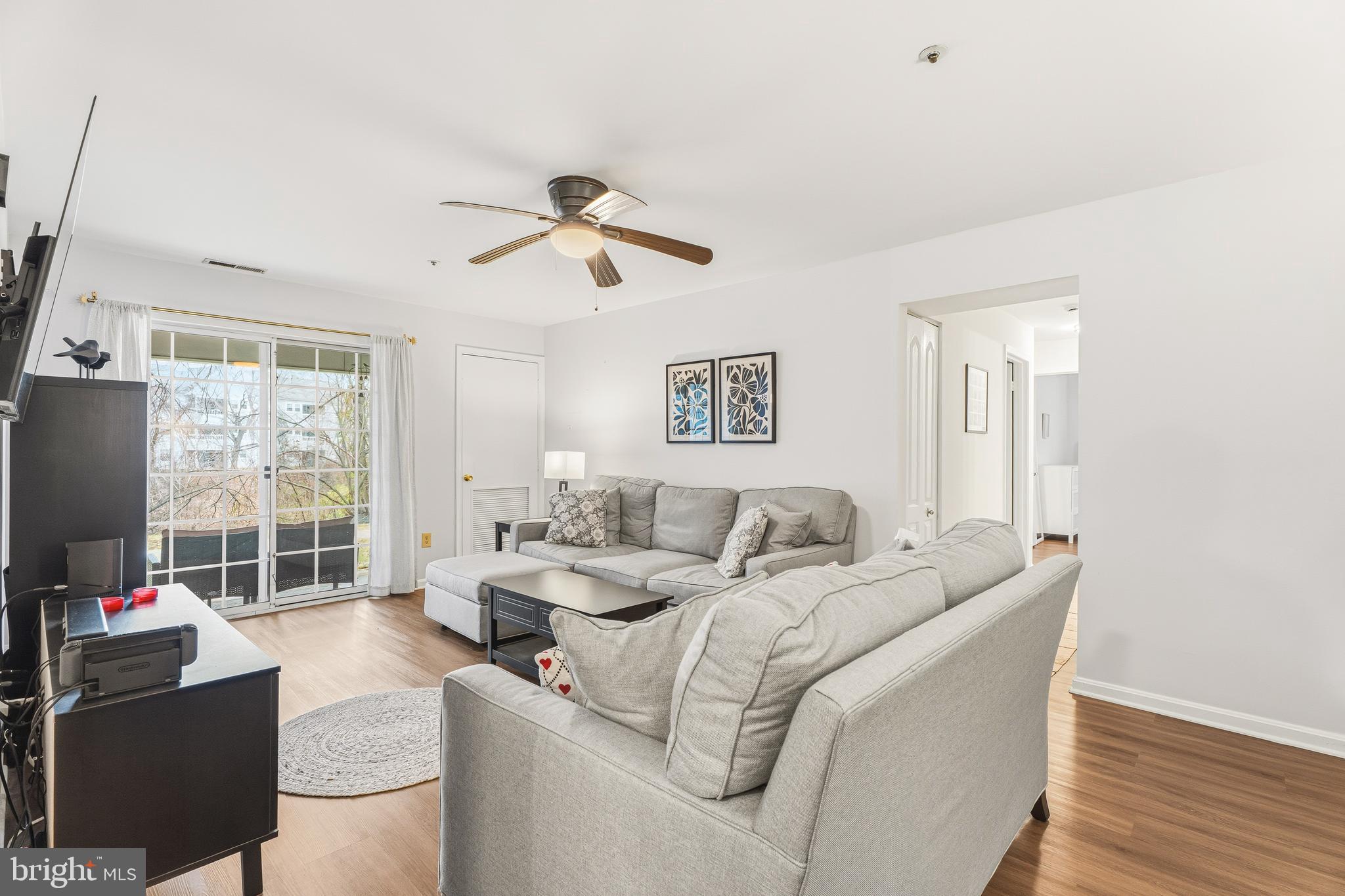 8495 Falls Run Road, Unit B Ellicott City, MD 21043 - Photo 12 of 34 a living room with furniture a flat screen tv and a large window