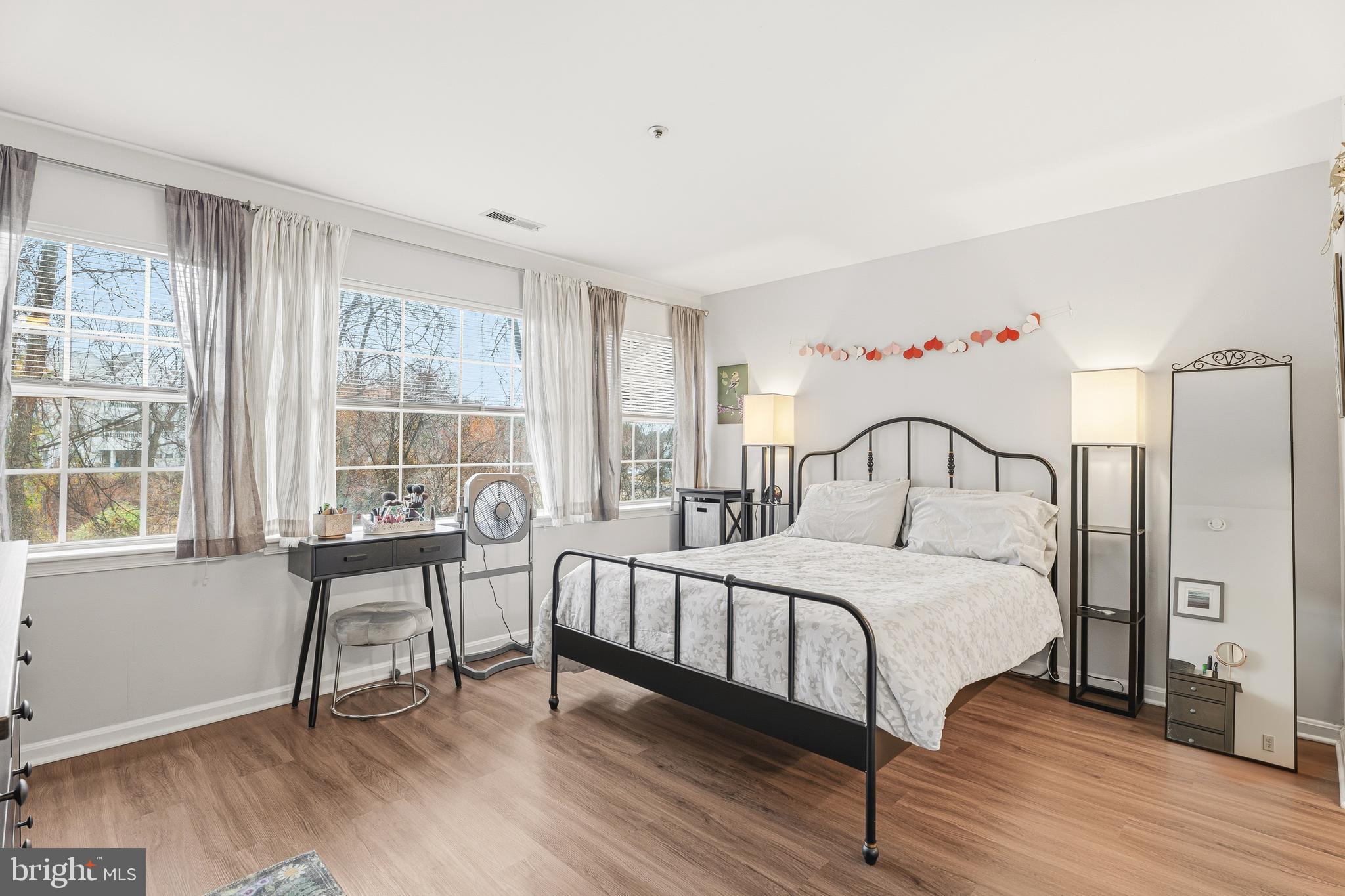 8495 Falls Run Road, Unit B Ellicott City, MD 21043 - Photo 19 of 34 a bedroom with a bed and a table with wooden floor