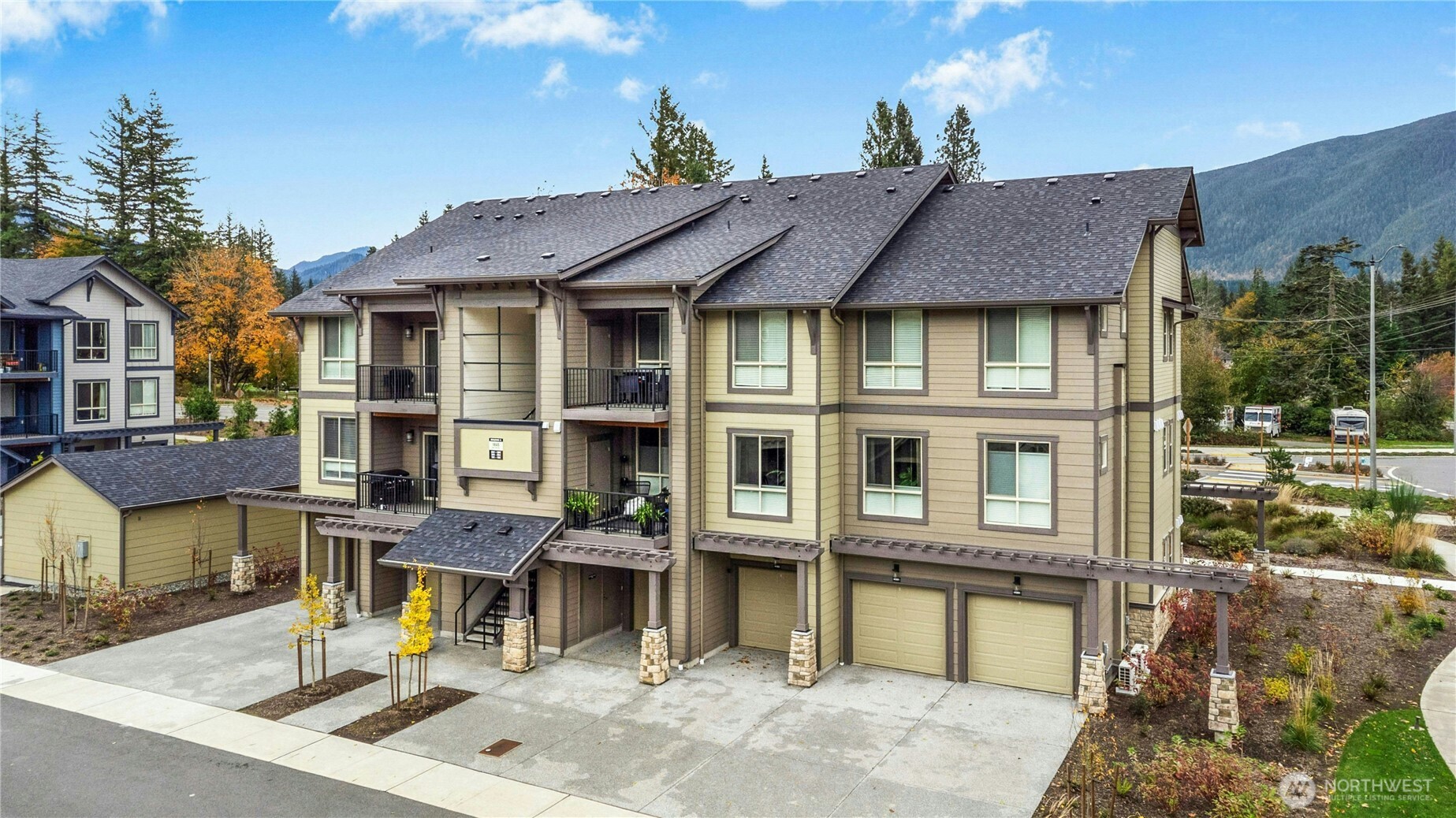 1845 Southeast 12th Place, Unit H204 North Bend, WA 98045 - Photo 1 of 31 a view of a big house with large windows and a small yard