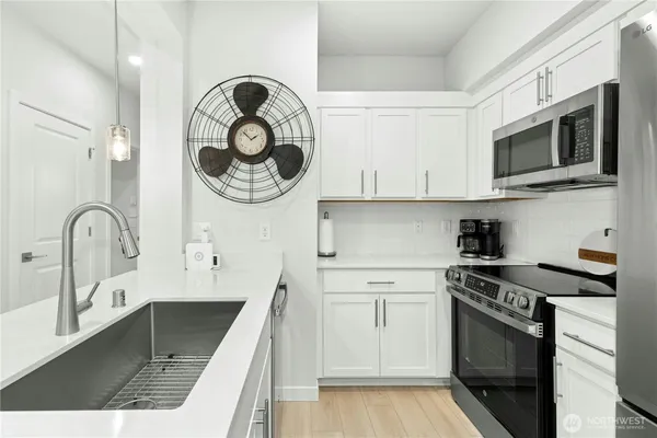a kitchen with stainless steel appliances a sink a stove a refrigerator and cabinets