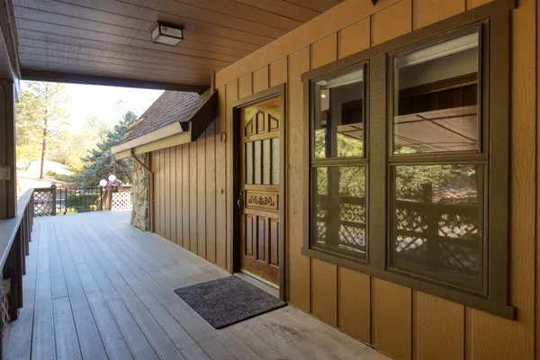 a patio with wooden floor table and chairs