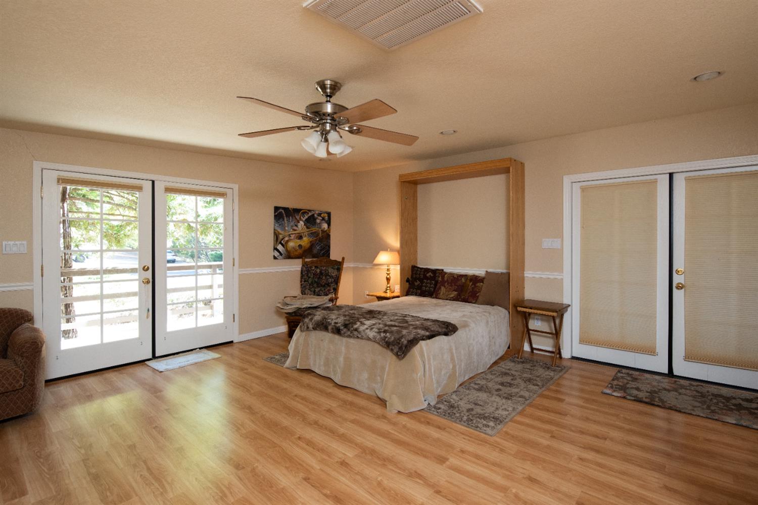 16979 Ridge Road Pine Grove, CA 95665 - Photo 32 of 68 a bedroom with a large bed a chandelier and a window