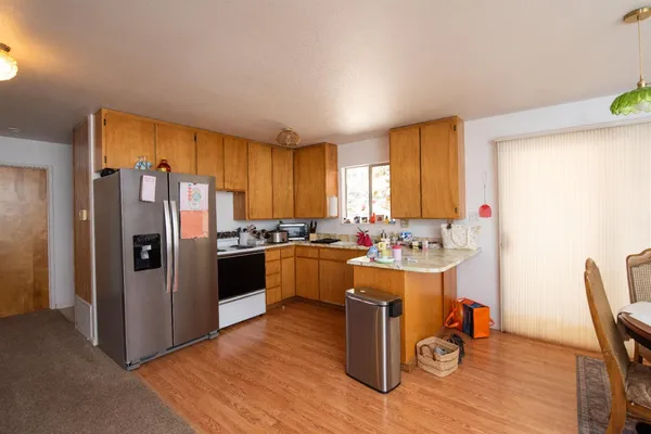 a view of a house with a yard and large trees
