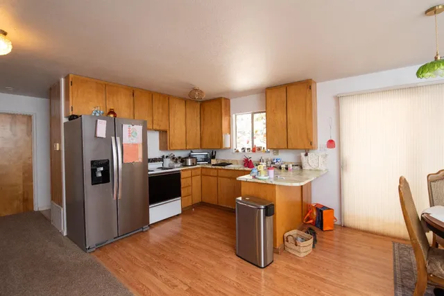 a view of a house with a yard and large trees