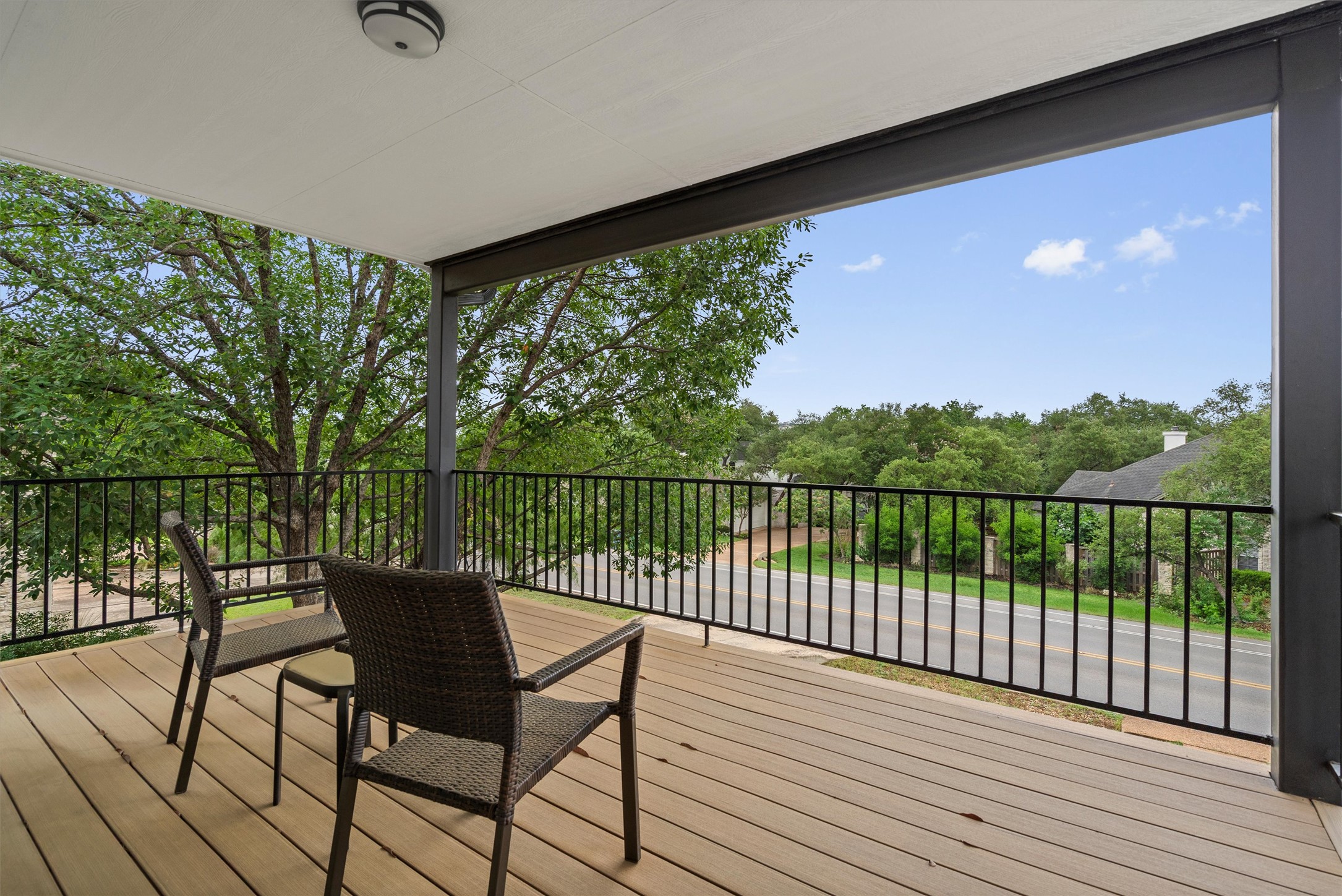 307 Hurst Creek Road Austin, TX 78734 - Photo 28 of 40 Expansive covered balcony featuring wood-finish decking, a black metal railing, and a white ceiling with a flush-mount light fixture