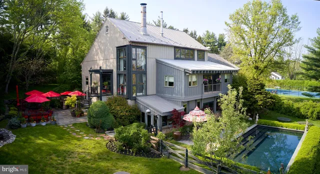 a front view of a house with yard and a fountain