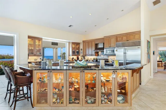 a room with granite countertop lots of wooden furniture and stainless steel appliances