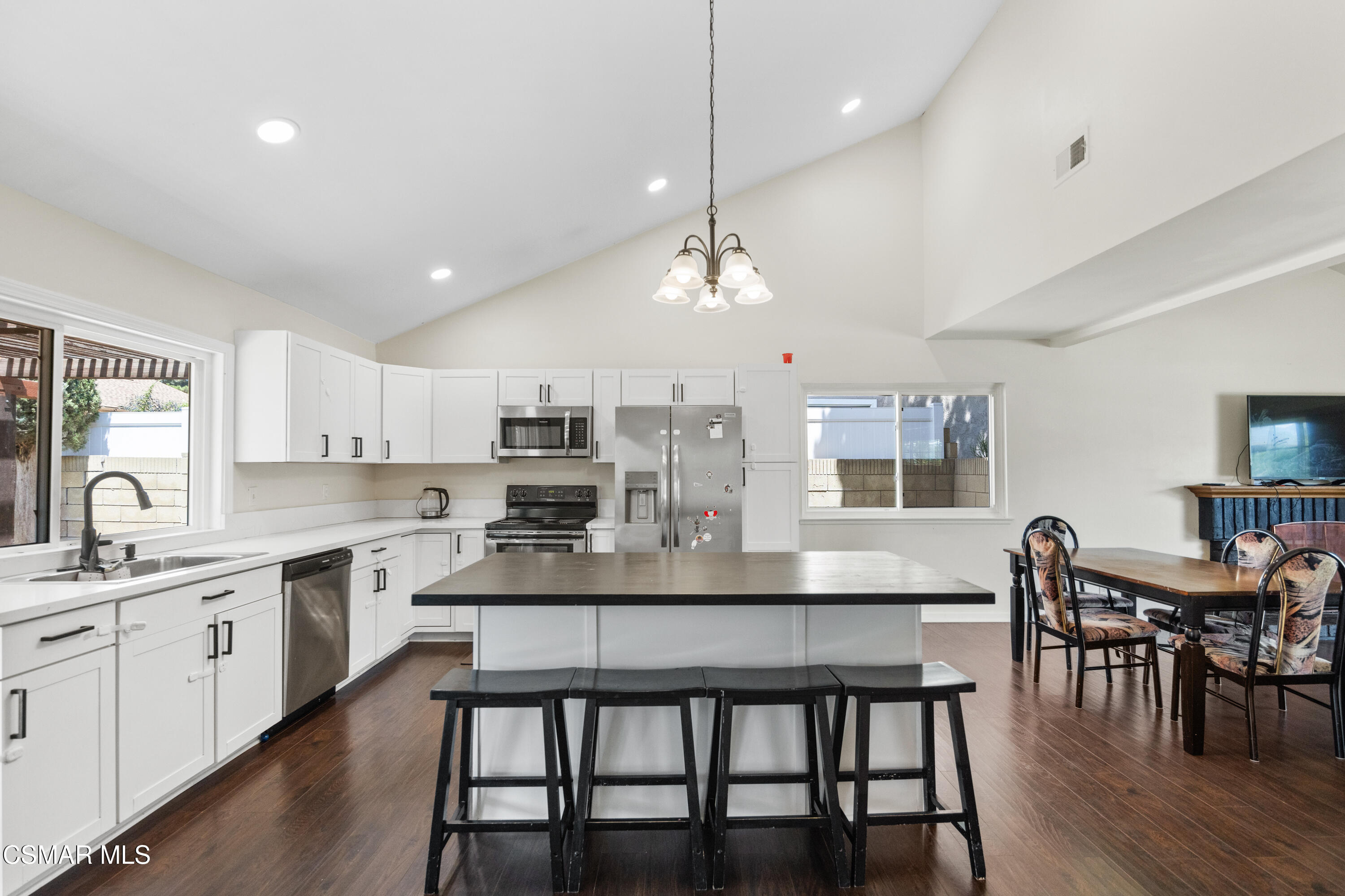 2367 St Clair Avenue Simi Valley, CA 93063 - Photo 11 of 41 a kitchen with stainless steel appliances kitchen island granite countertop a dining table chairs and white cabinets