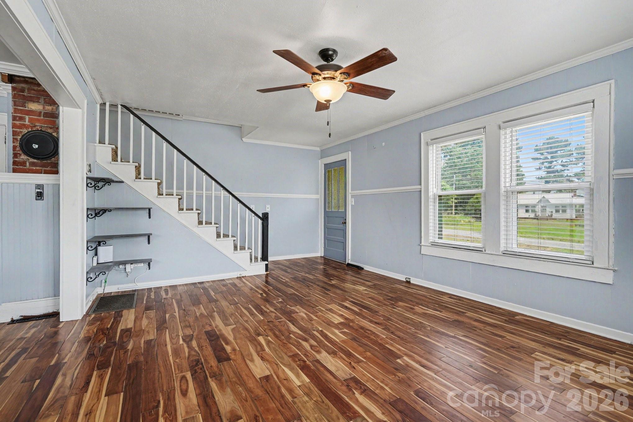 24359 Ridgecrest Road Locust, NC 28097 - Photo 3 of 26 a view of a livingroom with wooden floor a ceiling fan and windows