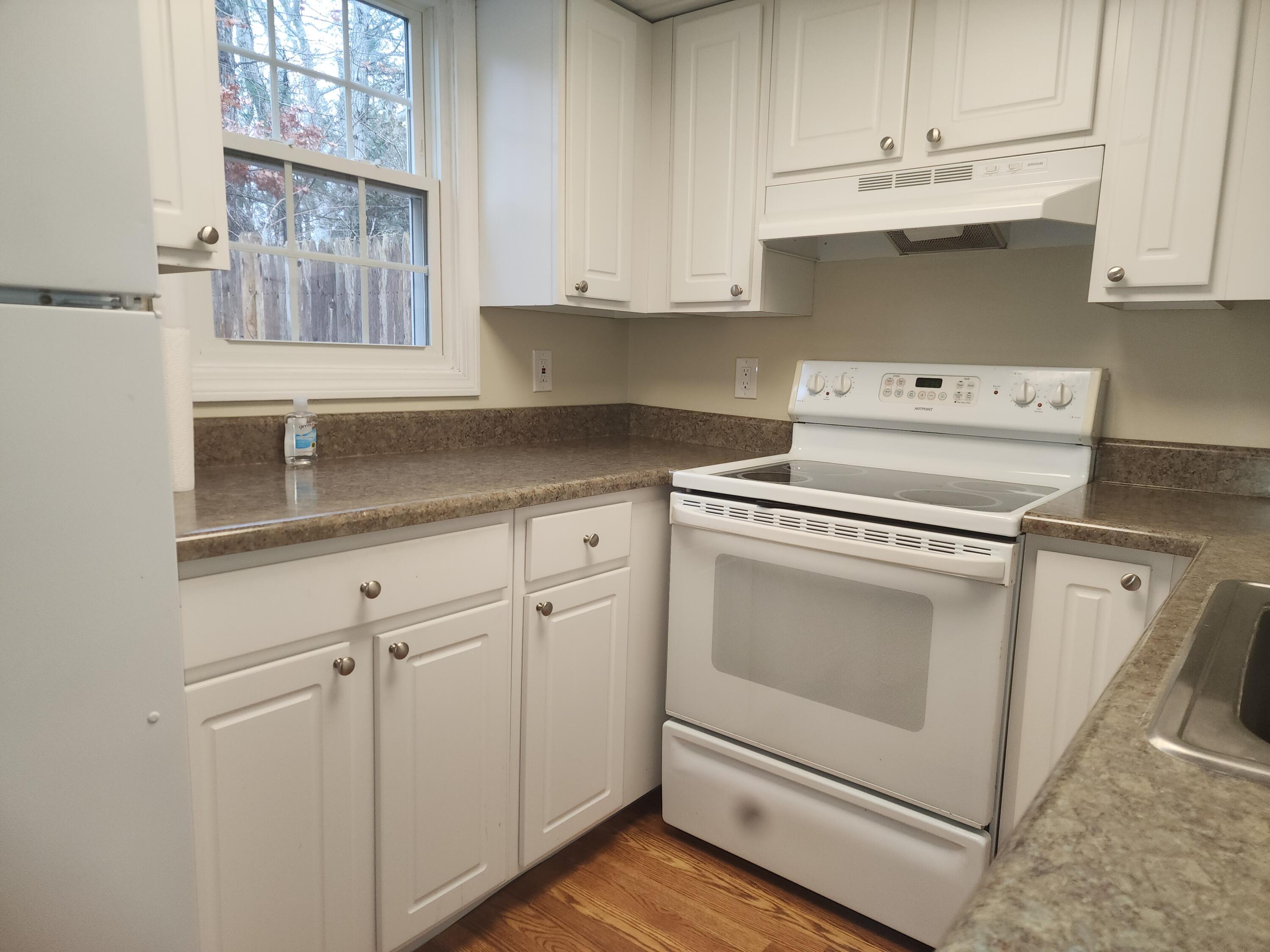 272 Craigville Beach Road, Unit 4 Hyannis, MA 02601 - Photo 12 of 33 a kitchen with granite countertop white cabinets and white appliances