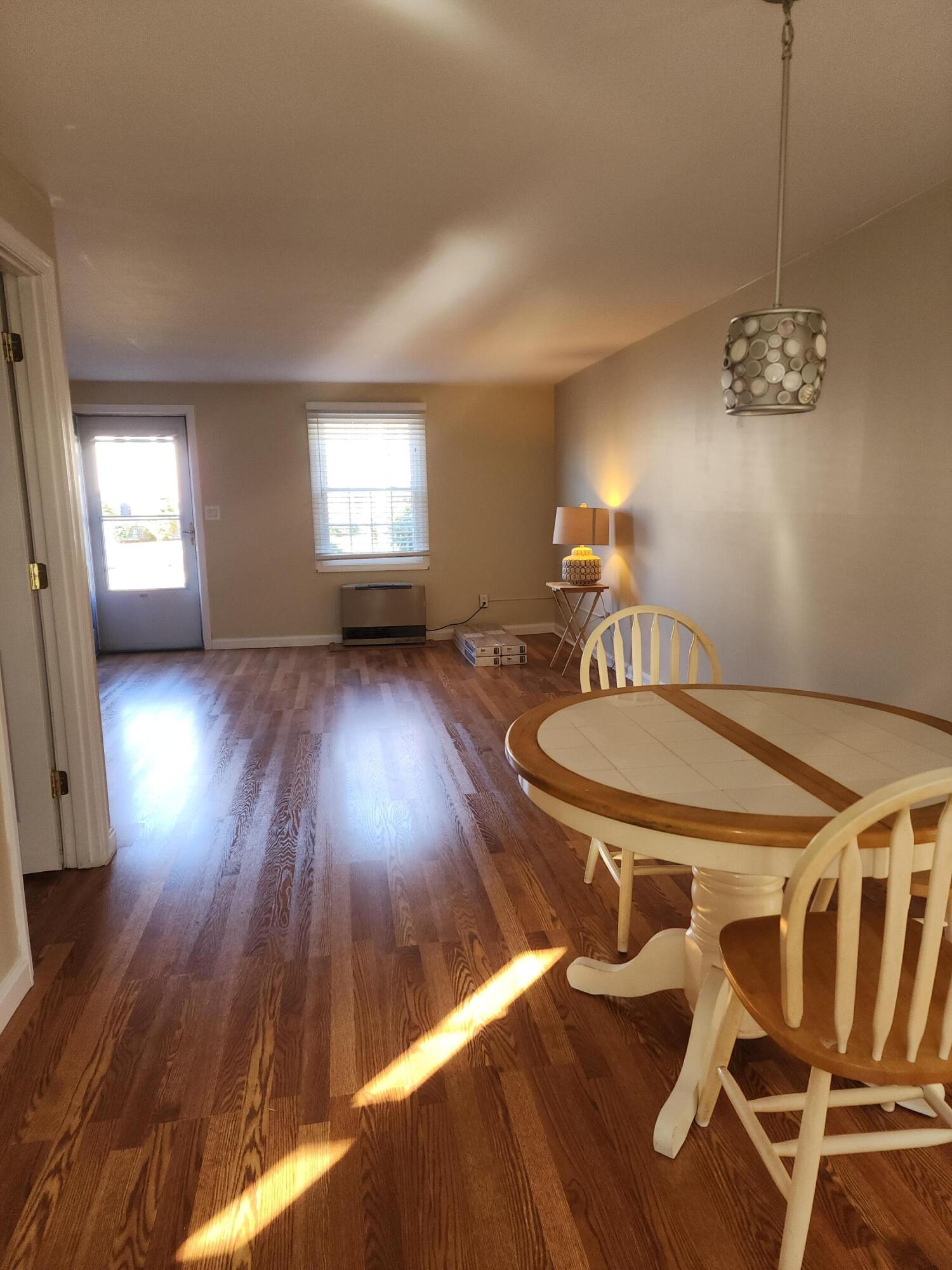 272 Craigville Beach Road, Unit 4 Hyannis, MA 02601 - Photo 7 of 33 a dining room with wooden floor a chandelier a wooden table and chairs