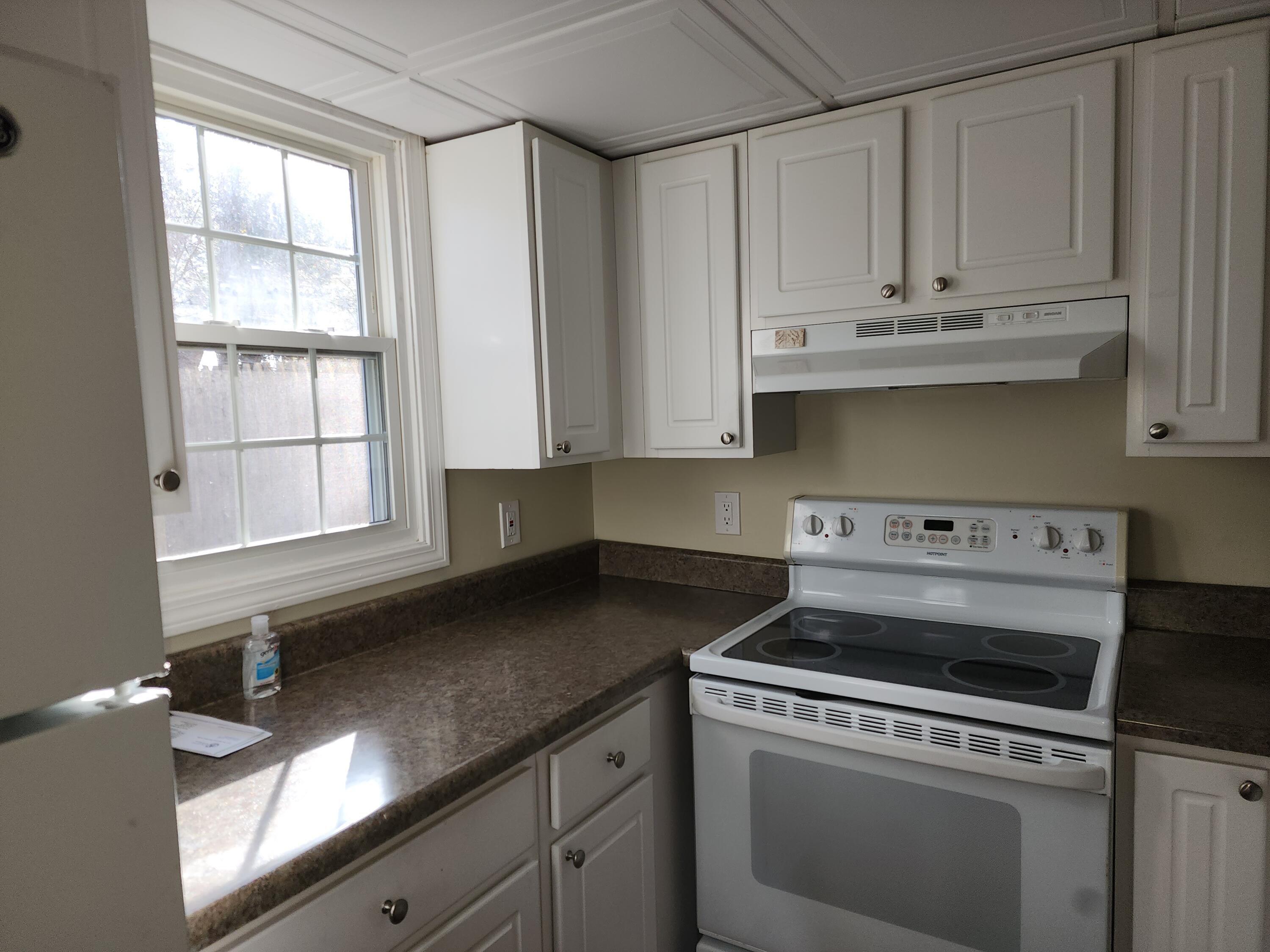 272 Craigville Beach Road, Unit 4 Hyannis, MA 02601 - Photo 9 of 33 a kitchen with granite countertop white cabinets and white appliances