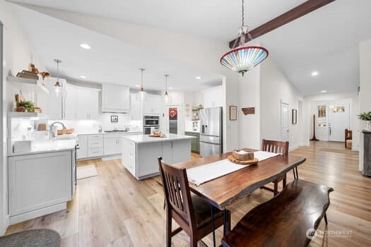 10218 45th Street East Edgewood, WA 98372 - Photo 6 of 34 a open dining room with stainless steel appliances kitchen island a table and chairs