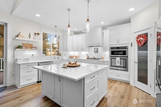10218 45th Street East Edgewood, WA 98372 - Photo 8 of 34 a kitchen with white cabinets and stainless steel appliances