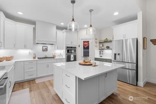 10218 45th Street East Edgewood, WA 98372 - Photo 9 of 34 a kitchen with refrigerator cabinets and wooden floor