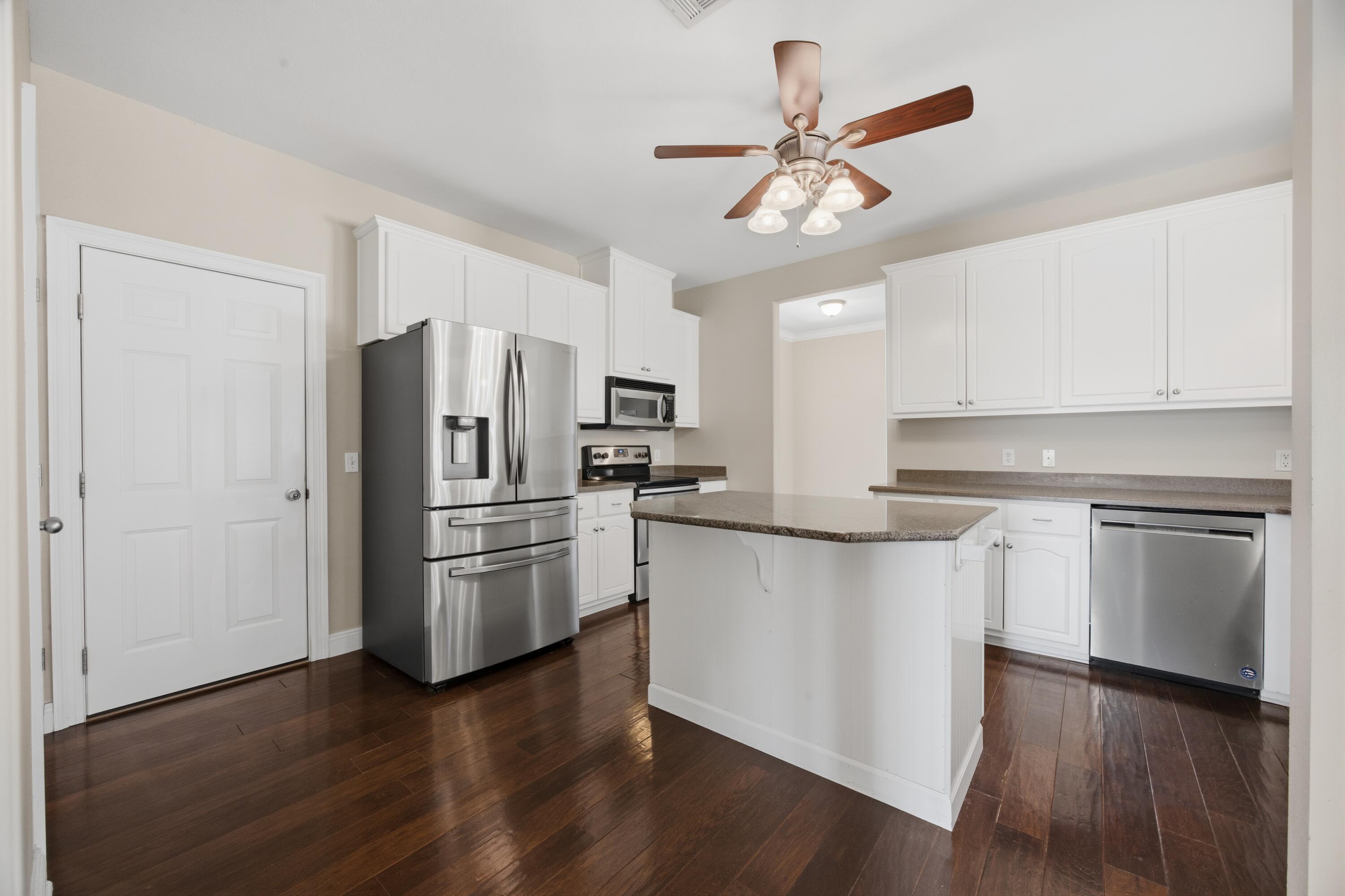 51 Tournament Lane Freeport, FL 32439 - Photo 25 of 71 a kitchen with a refrigerator cabinets and wooden floor